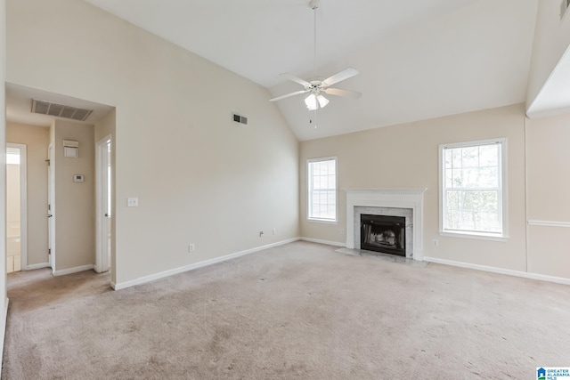 unfurnished living room with light colored carpet, ceiling fan, high vaulted ceiling, and a high end fireplace