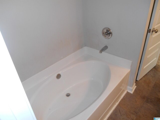 bathroom with a washtub, tile patterned floors, and vanity