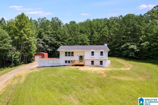 820 Boozer Rd, Heflin, AL 36264 - split foyer home with an outdoor structure, a front lawn, a garage, and a view of trees
