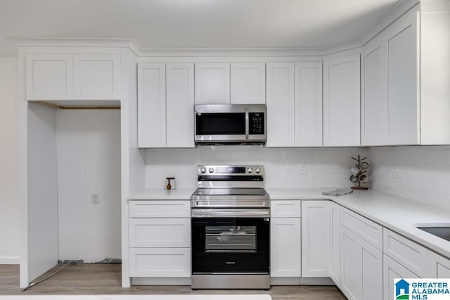 820 Boozer Rd, Heflin, AL 36264 - kitchen featuring stainless steel appliances, white cabinetry, and decorative backsplash