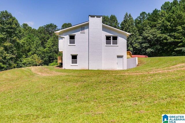 820 Boozer Rd, Heflin, AL 36264 - view of side of home with a yard, a chimney, and a view of trees