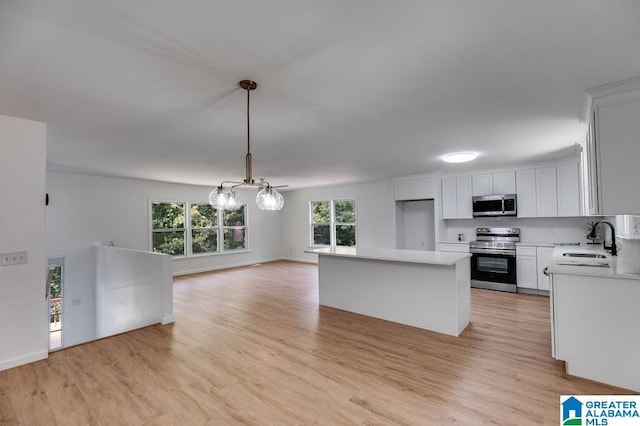 820 Boozer Rd, Heflin, AL 36264 - kitchen with appliances with stainless steel finishes, a sink, a chandelier, light wood-style flooring, and light countertops