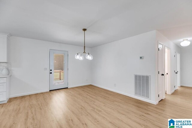 820 Boozer Rd, Heflin, AL 36264 - unfurnished dining area featuring light wood-type flooring, baseboards, and a chandelier