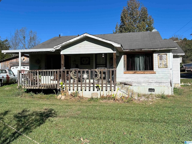 rear view of property featuring a lawn and a porch