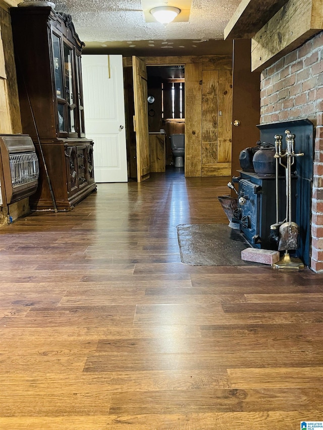 236 Shaw Ln, Sylacauga, AL 35150 - living area featuring heating unit, a wood stove, wood finished floors, and a textured ceiling