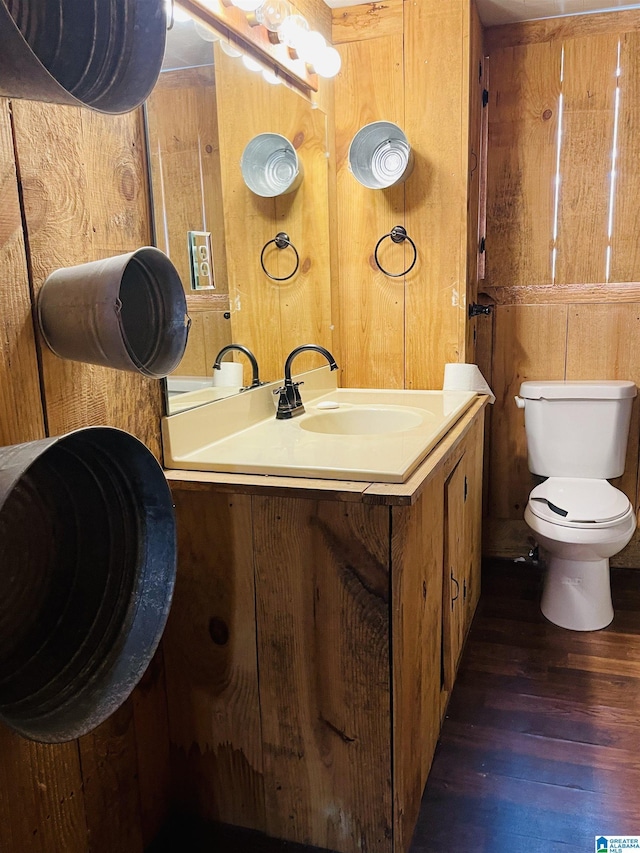 236 Shaw Ln, Sylacauga, AL 35150 - bathroom with toilet, wood finished floors, wooden walls, and vanity