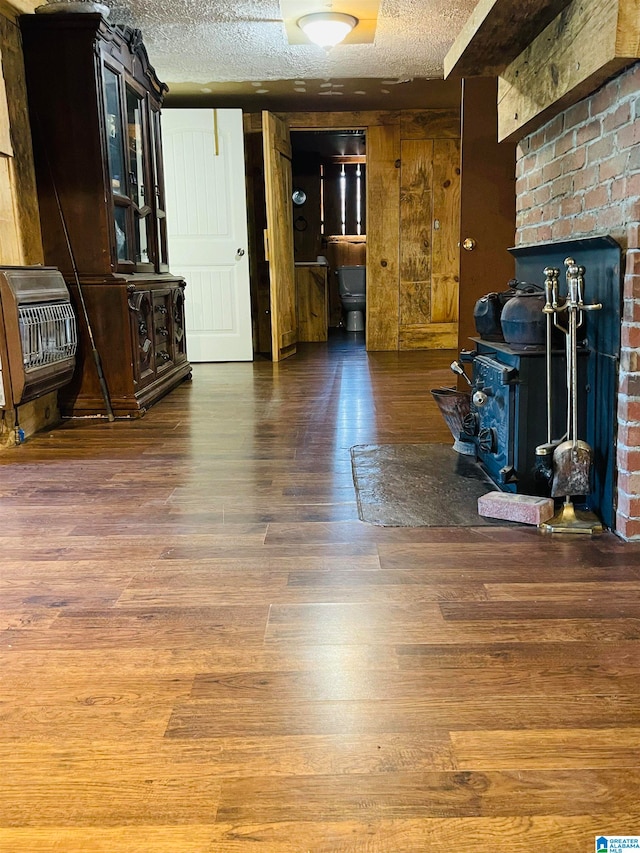 living room featuring dark hardwood / wood-style flooring, a textured ceiling, and heating unit