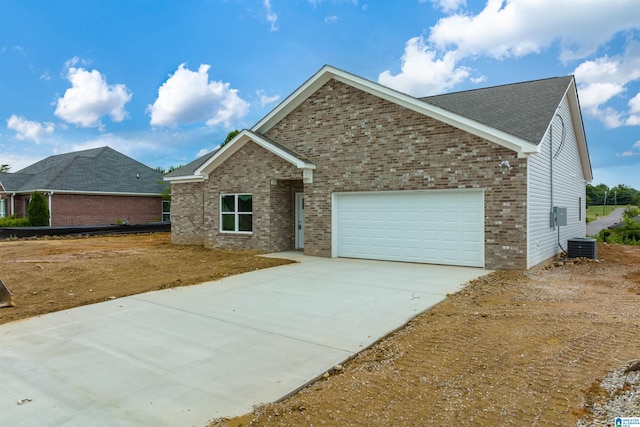 view of front of home featuring central air condition unit and a garage