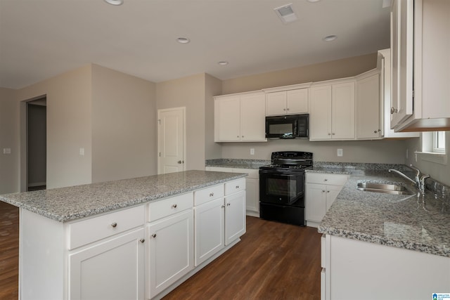 kitchen featuring white cabinetry, sink, black appliances, a kitchen island, and dark hardwood / wood-style flooring