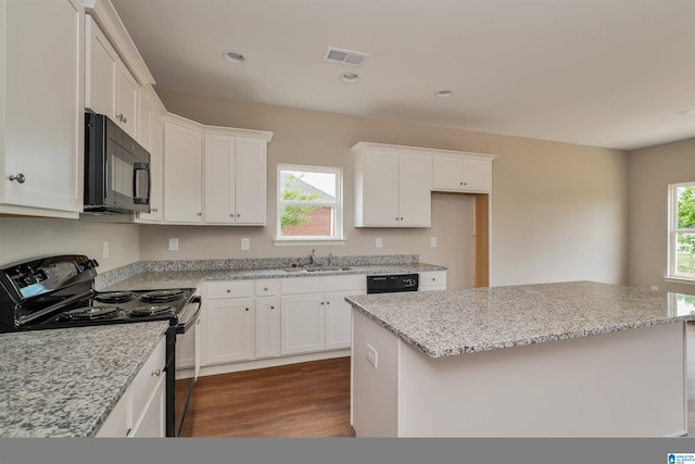 kitchen featuring black appliances, sink, and a kitchen island