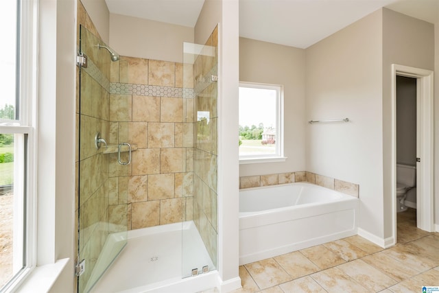 bathroom featuring toilet, tile patterned flooring, and separate shower and tub