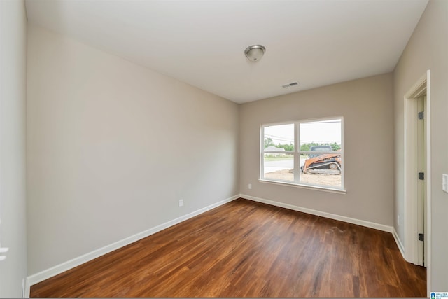 unfurnished bedroom with baseboards, visible vents, and dark wood-style flooring