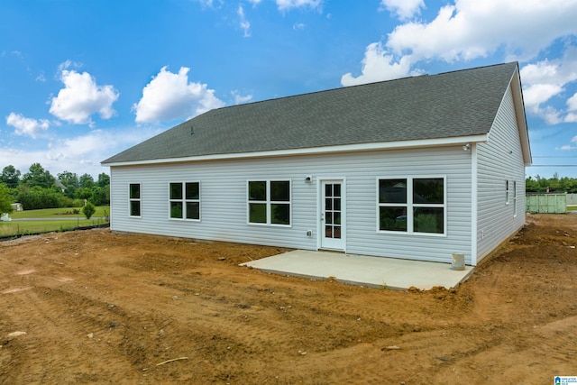 back of property with a patio and roof with shingles