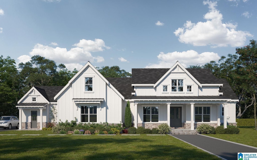 modern farmhouse style home featuring stone siding, a porch, board and batten siding, a front yard, and metal roof