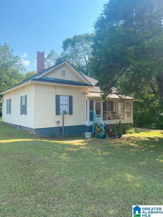 exterior space with a sunroom and a front yard