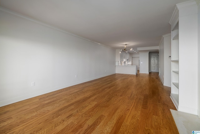 unfurnished living room featuring an inviting chandelier, light hardwood / wood-style flooring, and ornamental molding