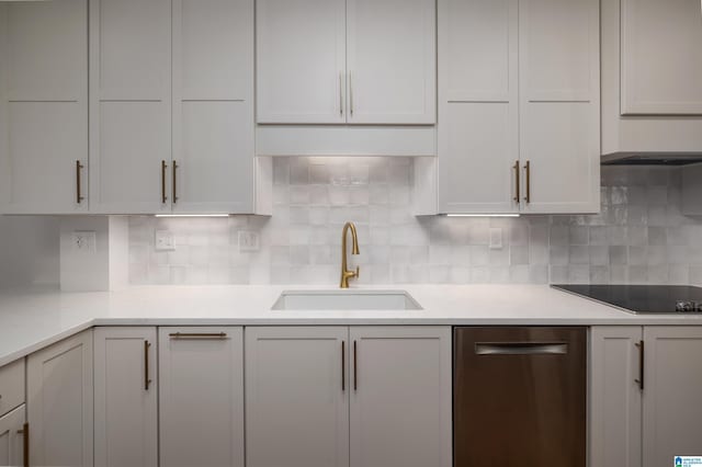 kitchen with black electric cooktop, sink, tasteful backsplash, and white cabinets