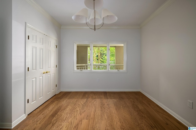 empty room with crown molding and light wood-type flooring