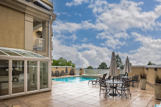 view of swimming pool featuring an in ground hot tub, pool water feature, and a patio