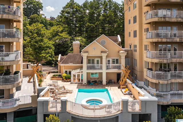 view of swimming pool featuring a hot tub and a patio area