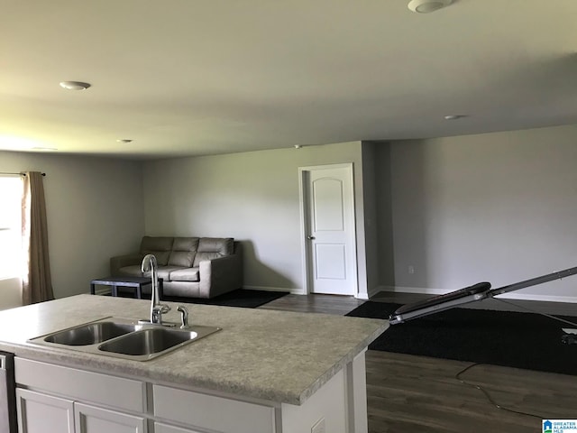 kitchen with dark hardwood / wood-style floors, sink, and white cabinets