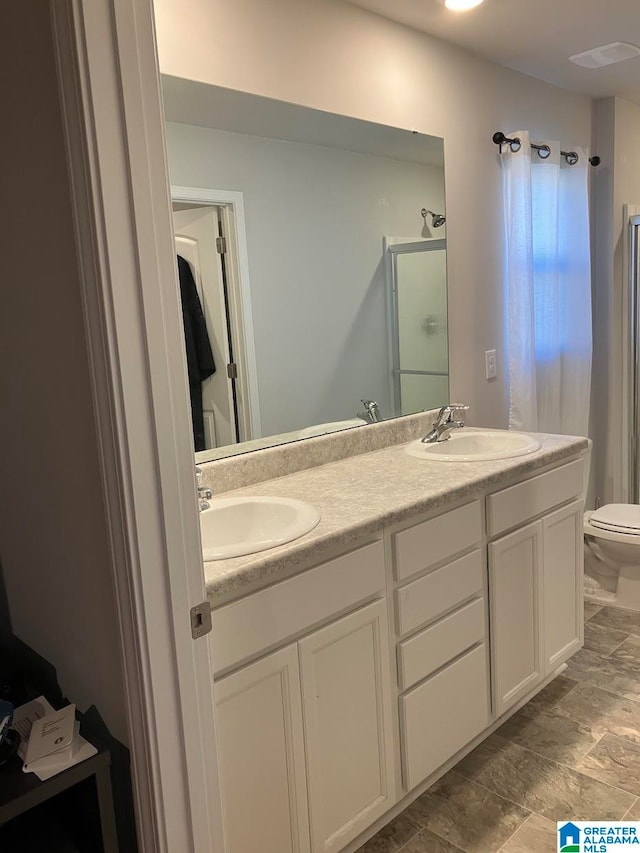 bathroom with dual bowl vanity and toilet