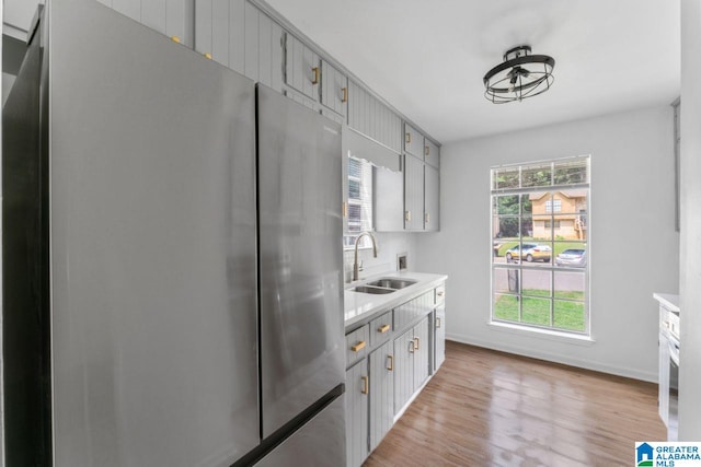 kitchen featuring sink, stainless steel fridge, and light wood-type flooring