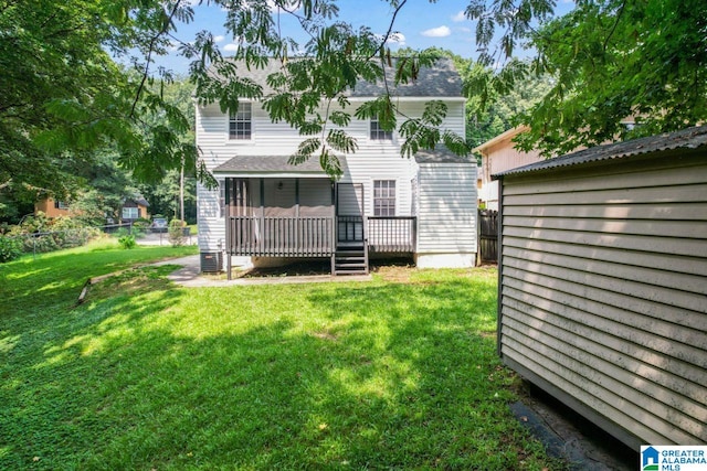 rear view of house with a deck and a lawn