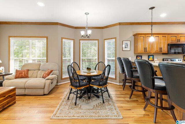 dining room with a notable chandelier, light wood-type flooring, and crown molding