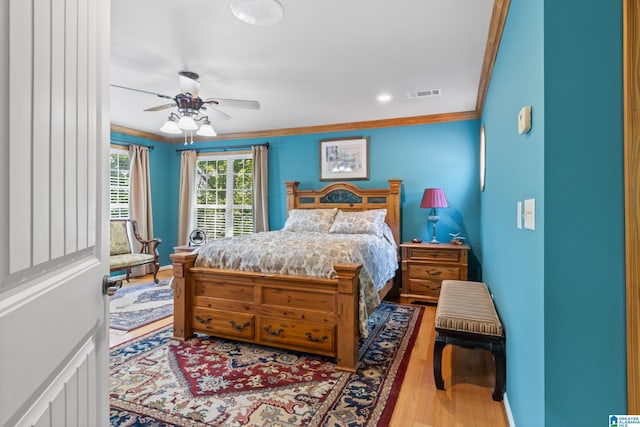 bedroom featuring hardwood / wood-style flooring, ceiling fan, and ornamental molding