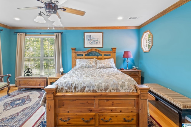 bedroom featuring ornamental molding, hardwood / wood-style floors, and ceiling fan