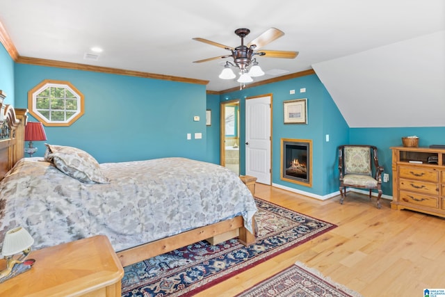 bedroom featuring lofted ceiling, ceiling fan, crown molding, connected bathroom, and light wood-type flooring