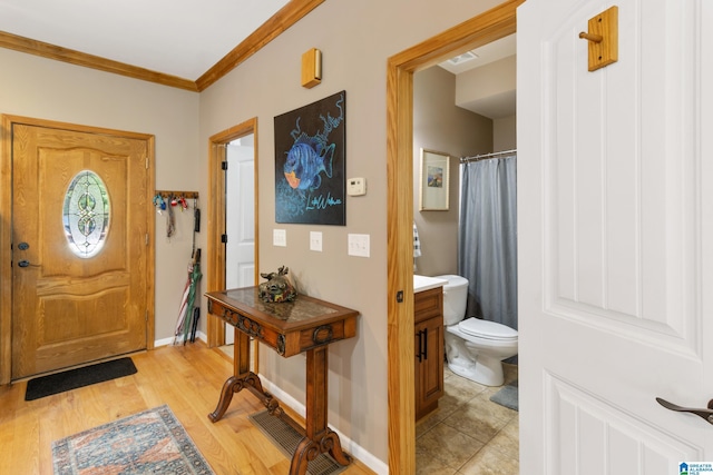 foyer featuring ornamental molding and light hardwood / wood-style flooring