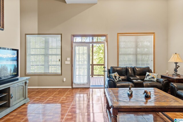 living room featuring a towering ceiling and light tile patterned floors