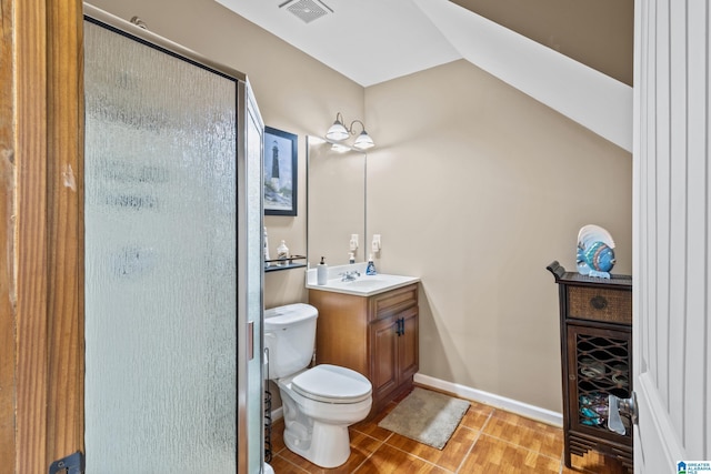 bathroom with toilet, tile patterned floors, vanity, vaulted ceiling, and walk in shower