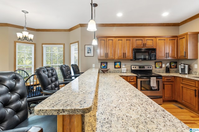 kitchen featuring a breakfast bar, hanging light fixtures, light hardwood / wood-style floors, light stone countertops, and stainless steel range with electric cooktop