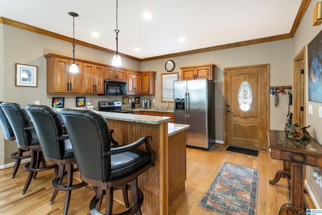 kitchen featuring pendant lighting, stainless steel appliances, kitchen peninsula, and light stone counters