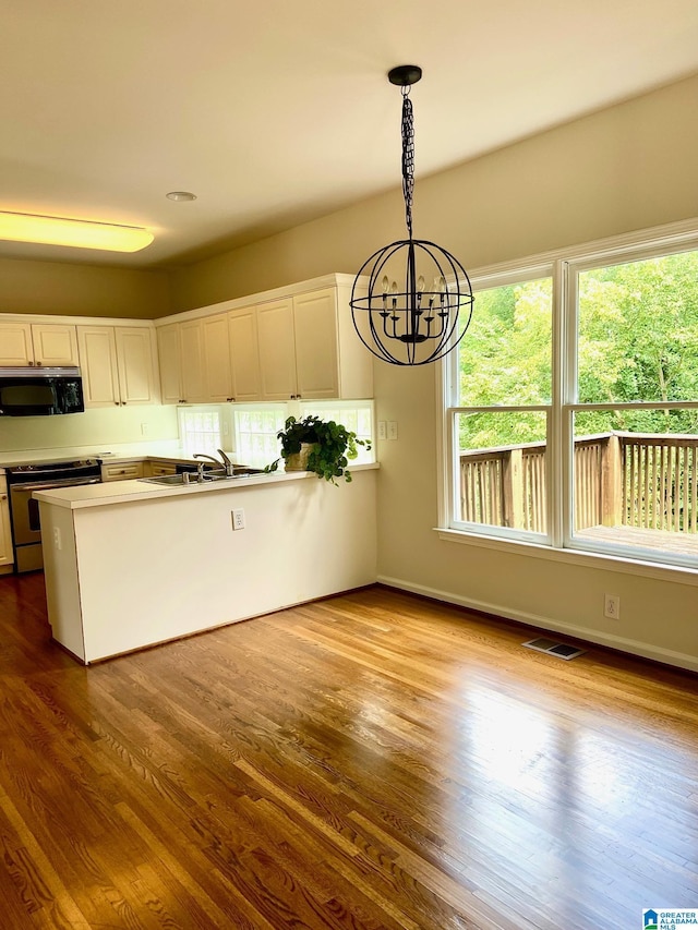 kitchen with visible vents, dark wood-style flooring, a notable chandelier, and stainless steel range with electric cooktop