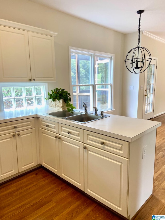 kitchen featuring dark hardwood / wood-style floors, sink, white cabinets, and decorative light fixtures