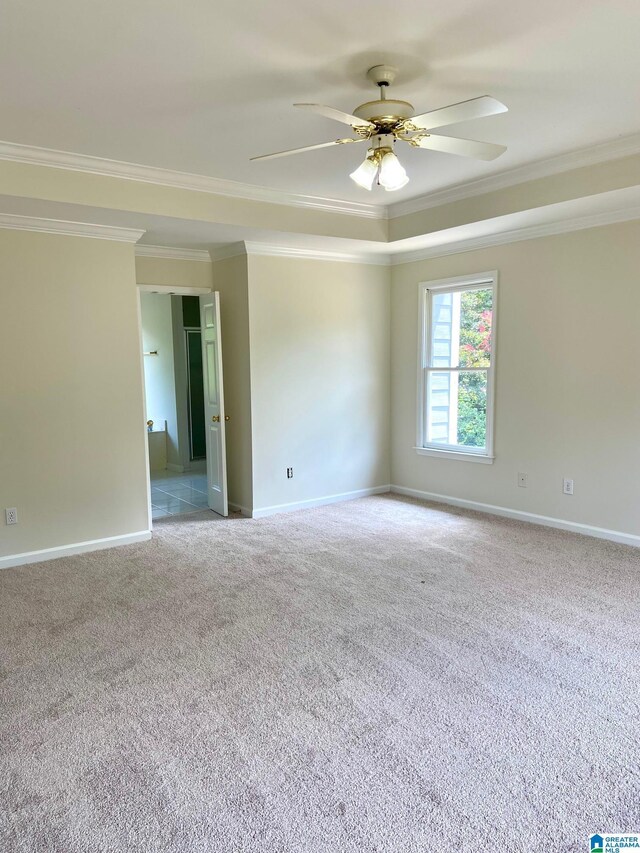 unfurnished room with ceiling fan, crown molding, and light colored carpet