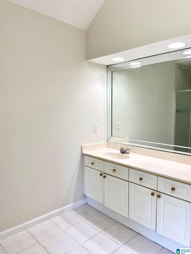 bathroom featuring lofted ceiling, vanity, and tile patterned flooring