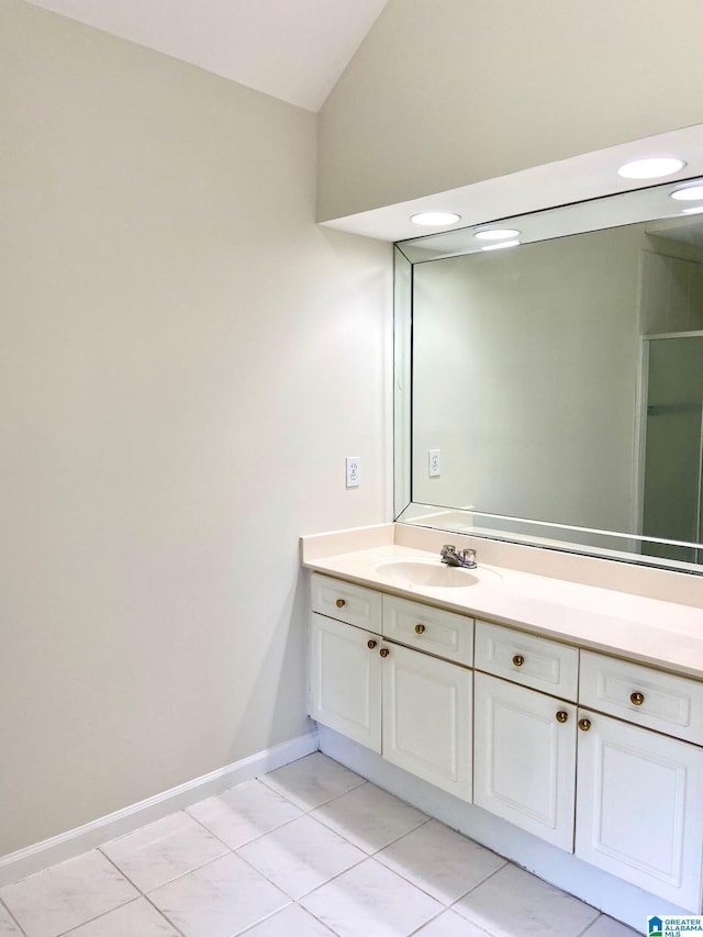 bathroom featuring vaulted ceiling, tile patterned floors, vanity, and baseboards