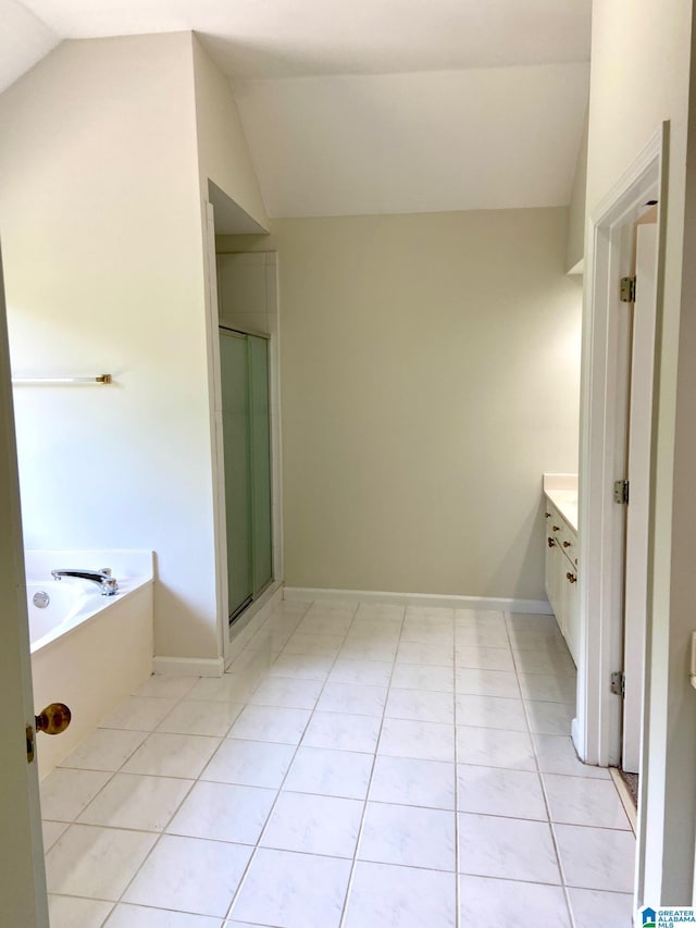 full bathroom featuring a garden tub, lofted ceiling, a stall shower, vanity, and tile patterned flooring