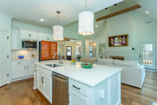 kitchen with dishwasher, light wood-type flooring, beamed ceiling, and sink