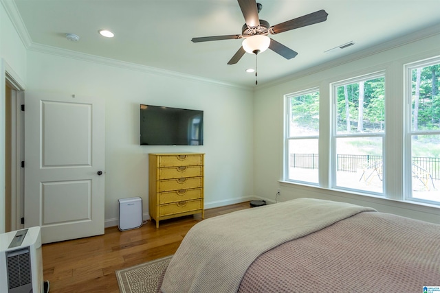 bedroom with ceiling fan, crown molding, and wood-type flooring