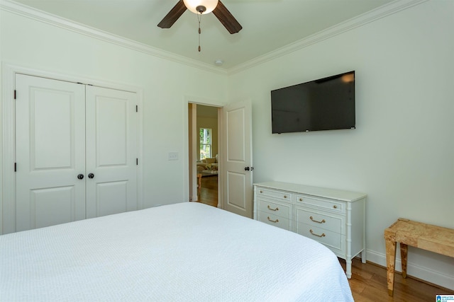 bedroom with ceiling fan, crown molding, hardwood / wood-style flooring, and a closet