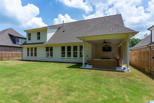 back of house featuring ceiling fan, a patio, an outdoor living space, and a lawn