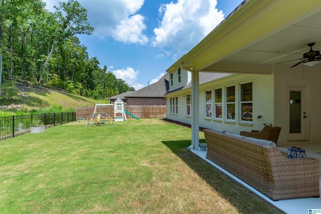 view of yard with ceiling fan and a playground