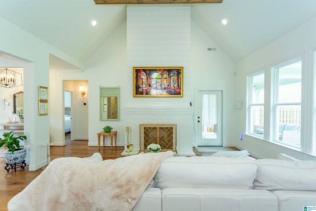 living room featuring beamed ceiling, a fireplace, hardwood / wood-style floors, and high vaulted ceiling