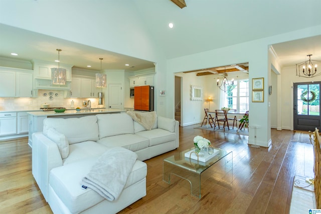 living room with light wood-type flooring, sink, and a healthy amount of sunlight